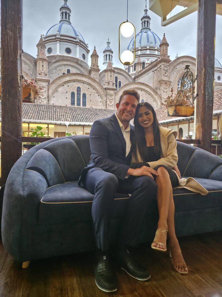 Kurt Conrad and Genesis Espinoza seated in front of cathedral domes in Ecuador